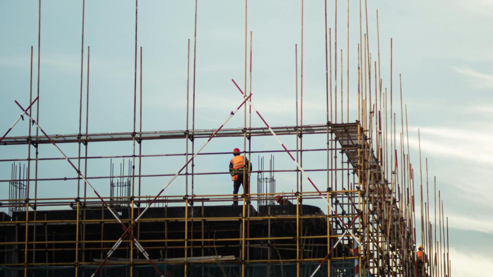 Construction Site at Sunset with Workers on Scaffolding