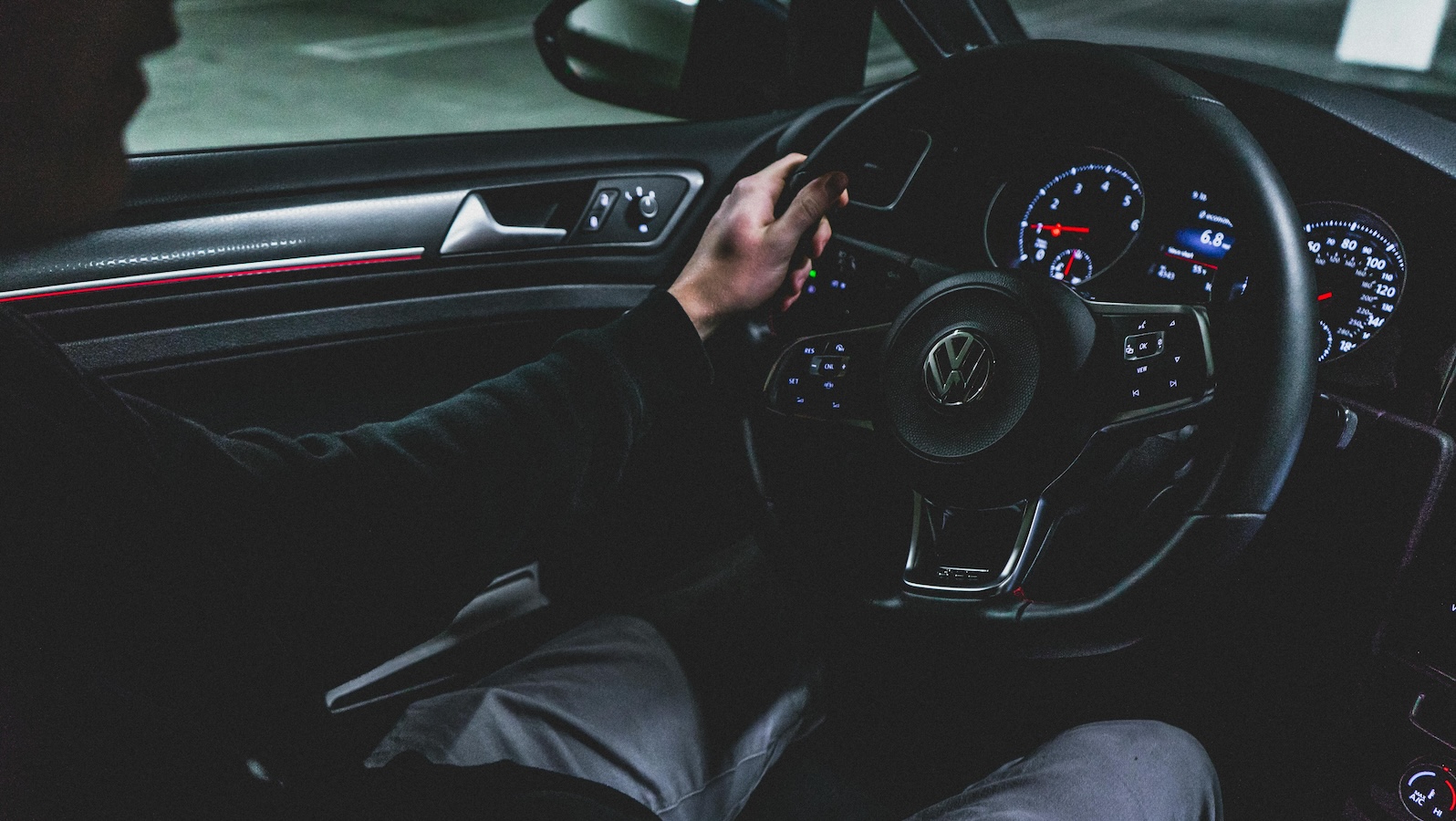 Person driving a car with a dark interior