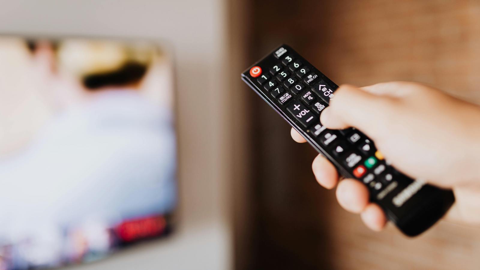 Person Pressing the Button of a Remote Control