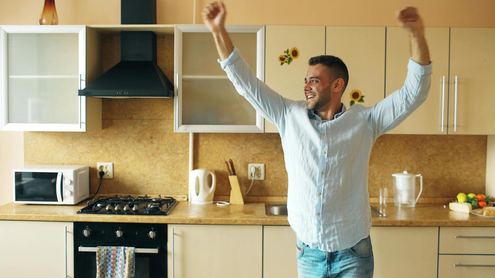 Happy Man Celebrating in Modern Kitchen