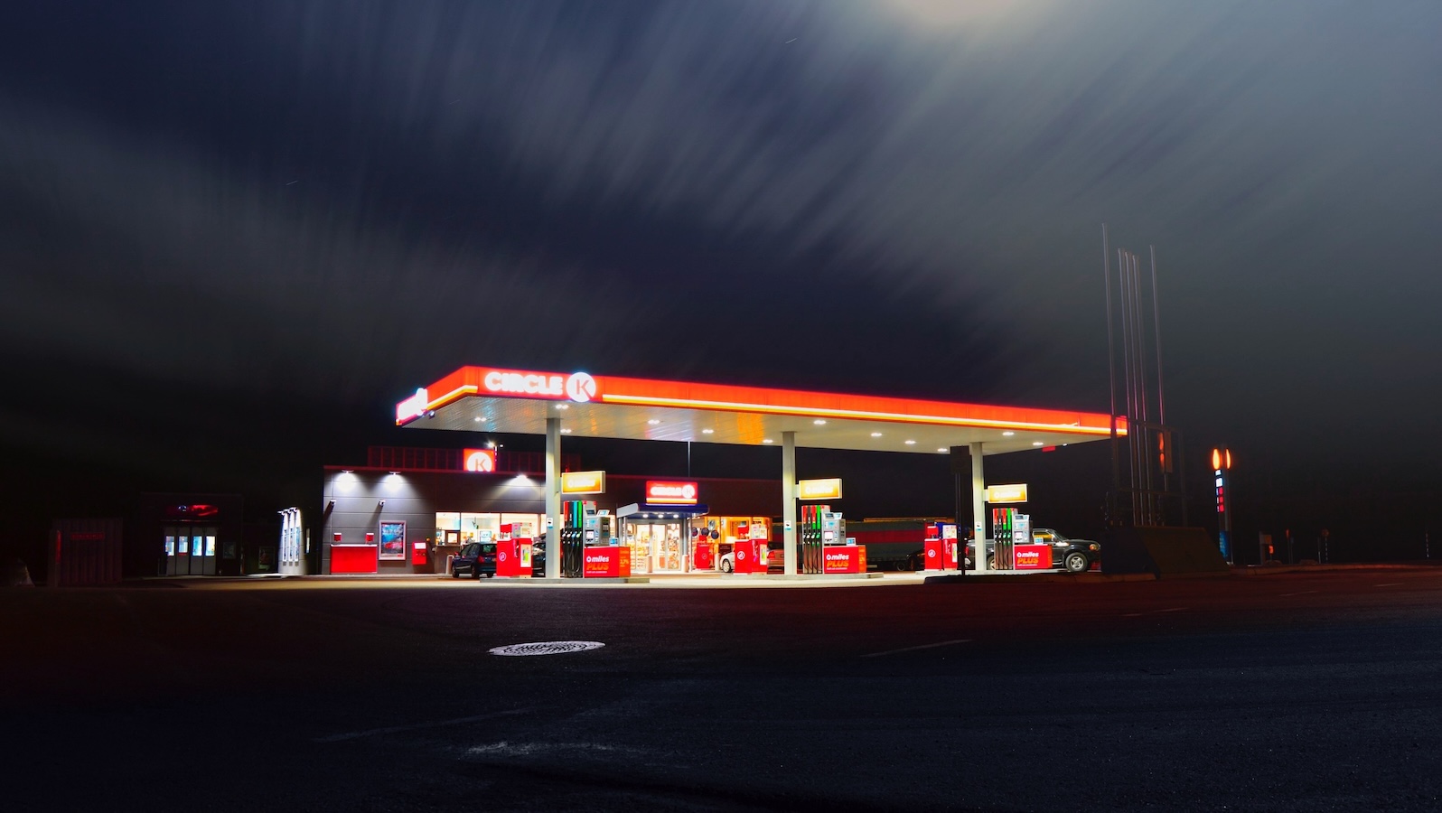 Bright red gas station illuminated against a black night