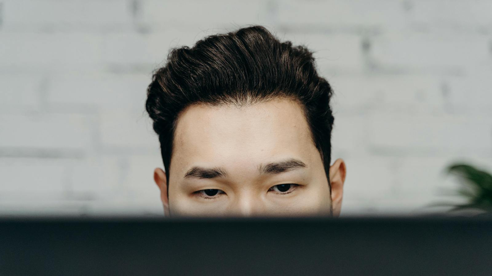Close-up of a man intensely focused, working indoors in an office environment.