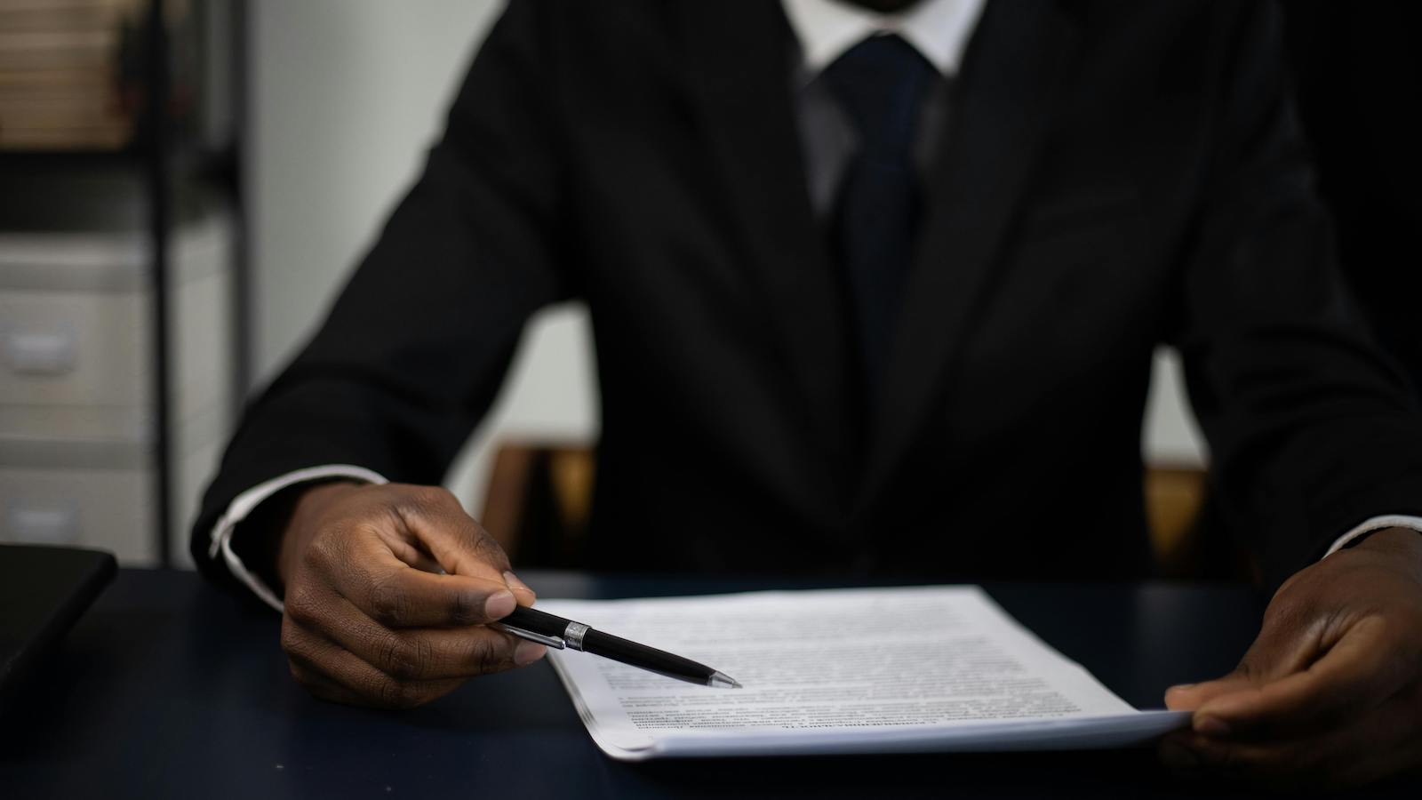 Close-up of a professional in a suit reviewing a document with focused attention