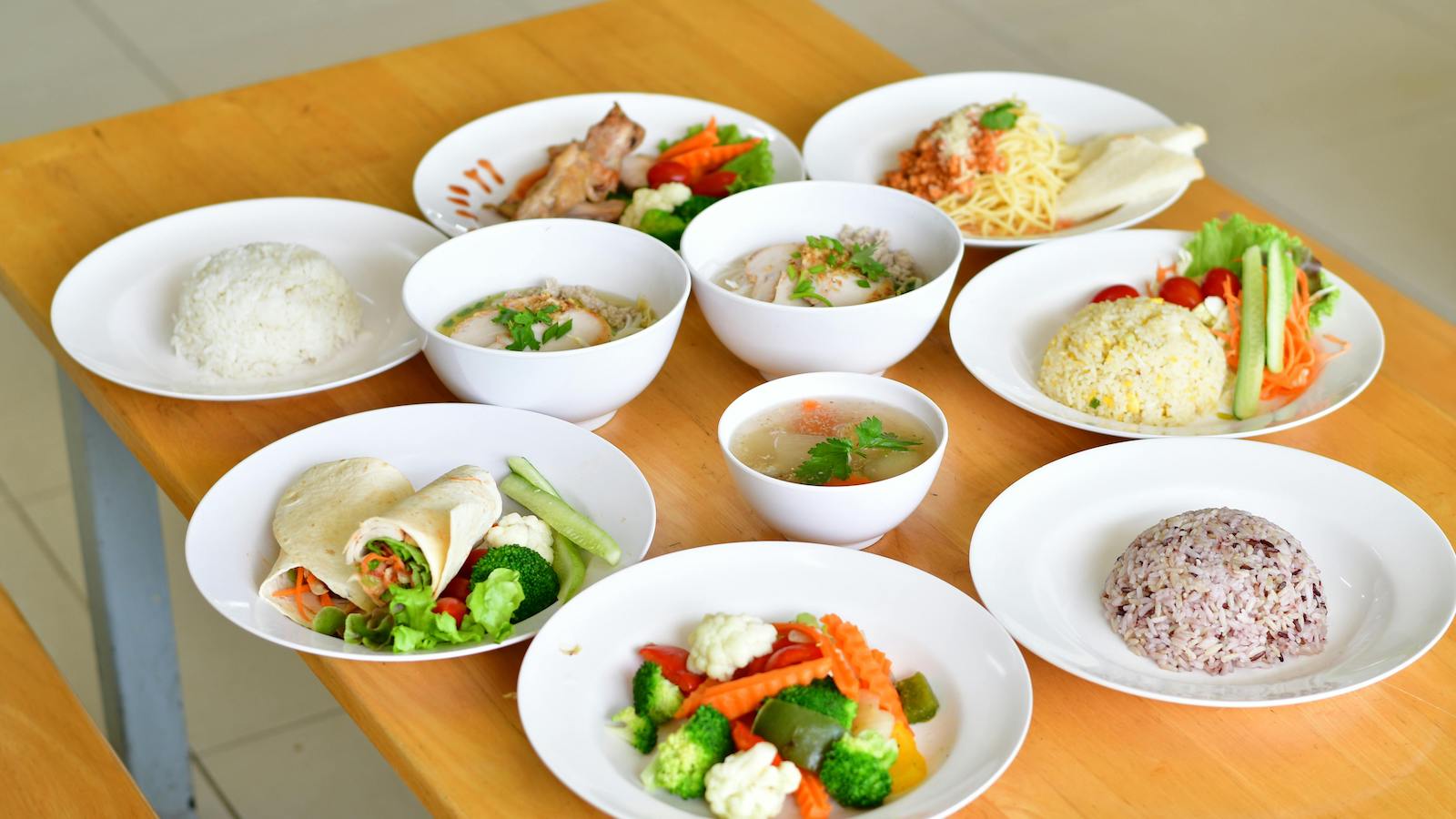 A variety of nutritious dishes displayed on a wooden table, showcasing diverse healthy meals
