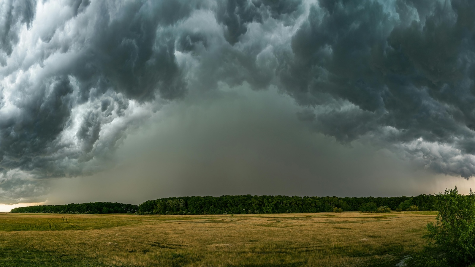 Dust cloud and storm on the horizon under cloudy sky
