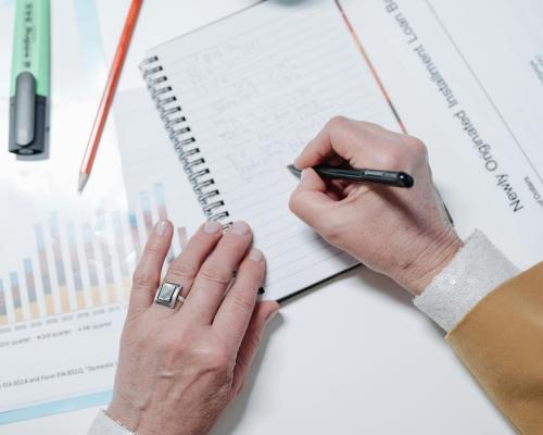 Person Writing on Notebook