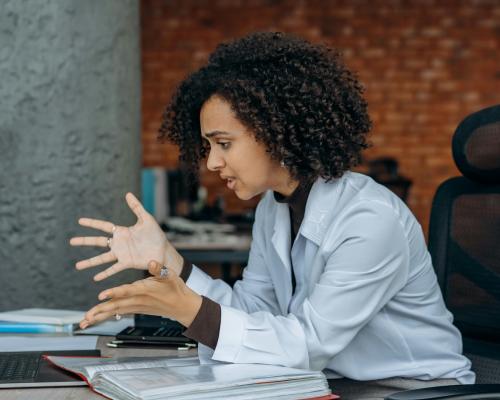 A Frustrated Woman Sitting on a Swivel Chair while Looking at the Screen of a Laptop