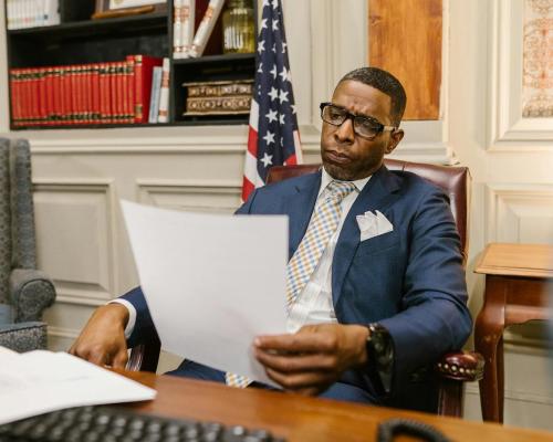 An Attorney in Blue Suit Holding a Document while Sitting