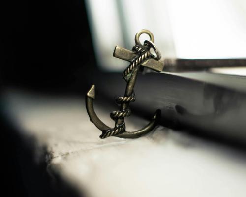 Decorative small anchor placed on weathered windowsill