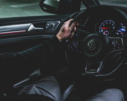 Person driving a car with a dark interior