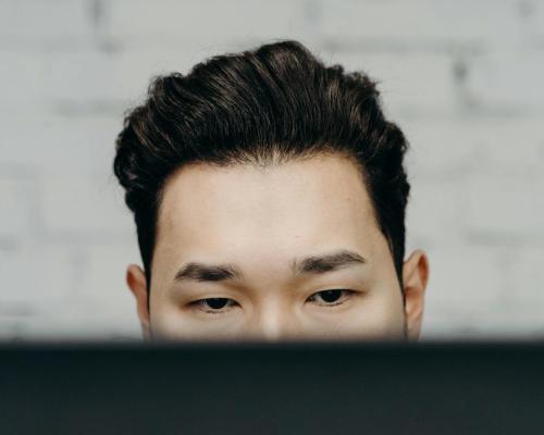 Close-up of a man intensely focused, working indoors in an office environment.