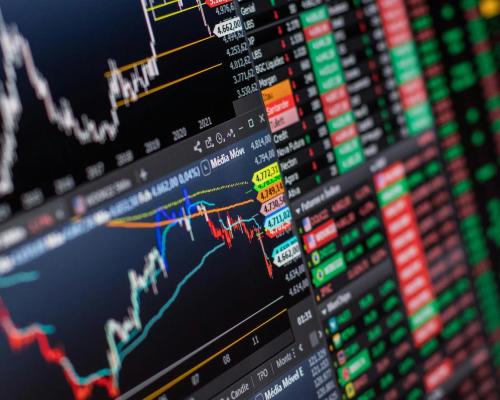 Detailed view of stock market charts and data on a monitor, showcasing market trends.