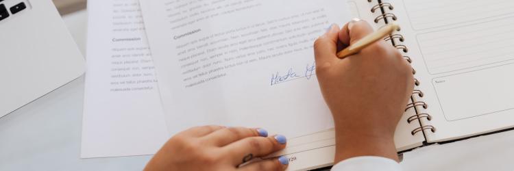 Person signing name at the bottom of a contract