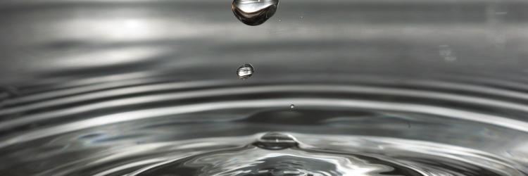 Water droplet splashing into a puddle