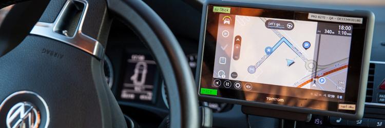 Steering wheel in a car with a GPS device on the dashboard