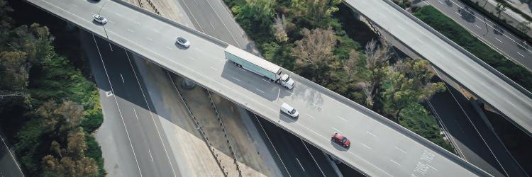 Overhead view of a freeway with several cars driving on it