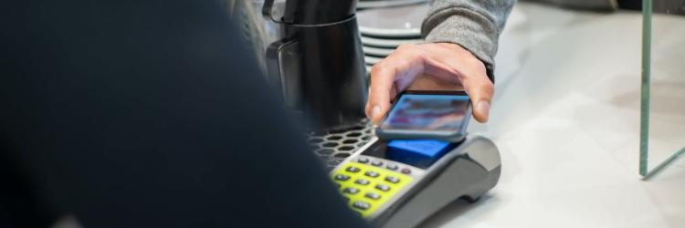 Person holding a smart phone up to register to conduct a mobile payment