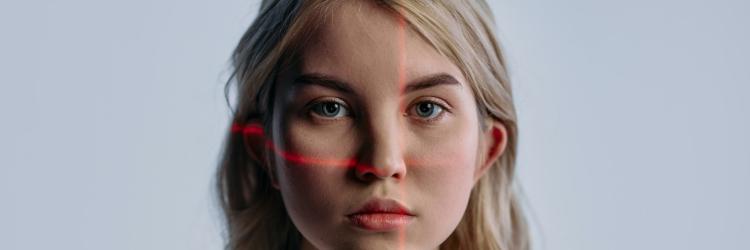 Blonde woman looking at the camera with red lines across her face