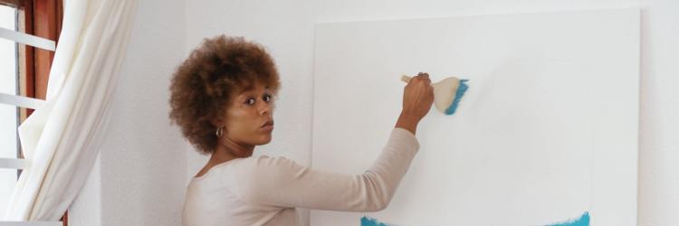 Woman painting a canvas light blue