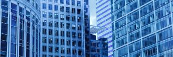 Blue tinted view of tall glass office buildings