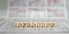 block letters that spell out "inflation" with graphs and charts in the background representing economic patterns