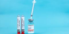 Covid test and vaccine on a blue background