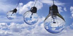 Three lightbulbs in front of a cloudy blue sky