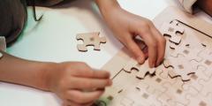 hands doing a wooden puzzle
