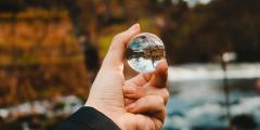 Person holding a clear sphere in nature
